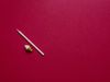 A white pencil on a red background, with an ice cream cone shaped eraser