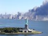 Smoke billows across New York City. The Statue of Liberty in the foreground. September 11th.